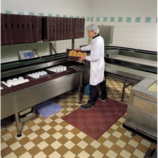 Crvena nitrilna podloga Sanitop Red u upotrebi na vlažnom podu u industrijskom pogonu za preradu i pakovanje prehrambenih proizvoda.
